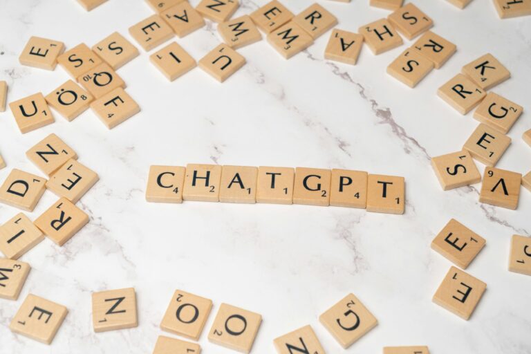 Wooden letter tiles spelling 'ChatGPT' on a marble surface, creating a tech concept image.