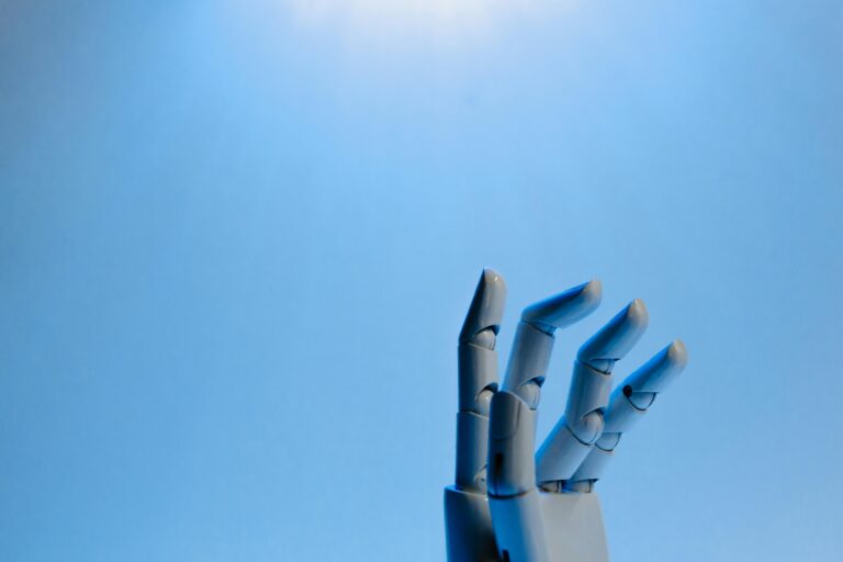 Robotic hand with articulated fingers reaching towards the sky on a blue background.